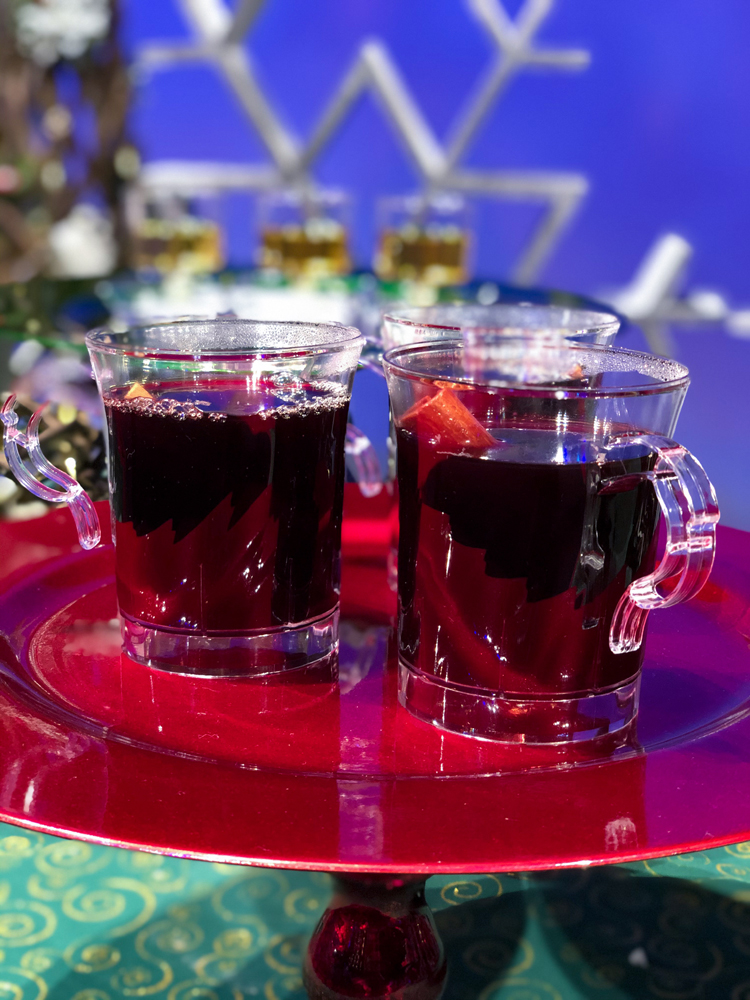 Clear plastic cups with red wine on a red plate